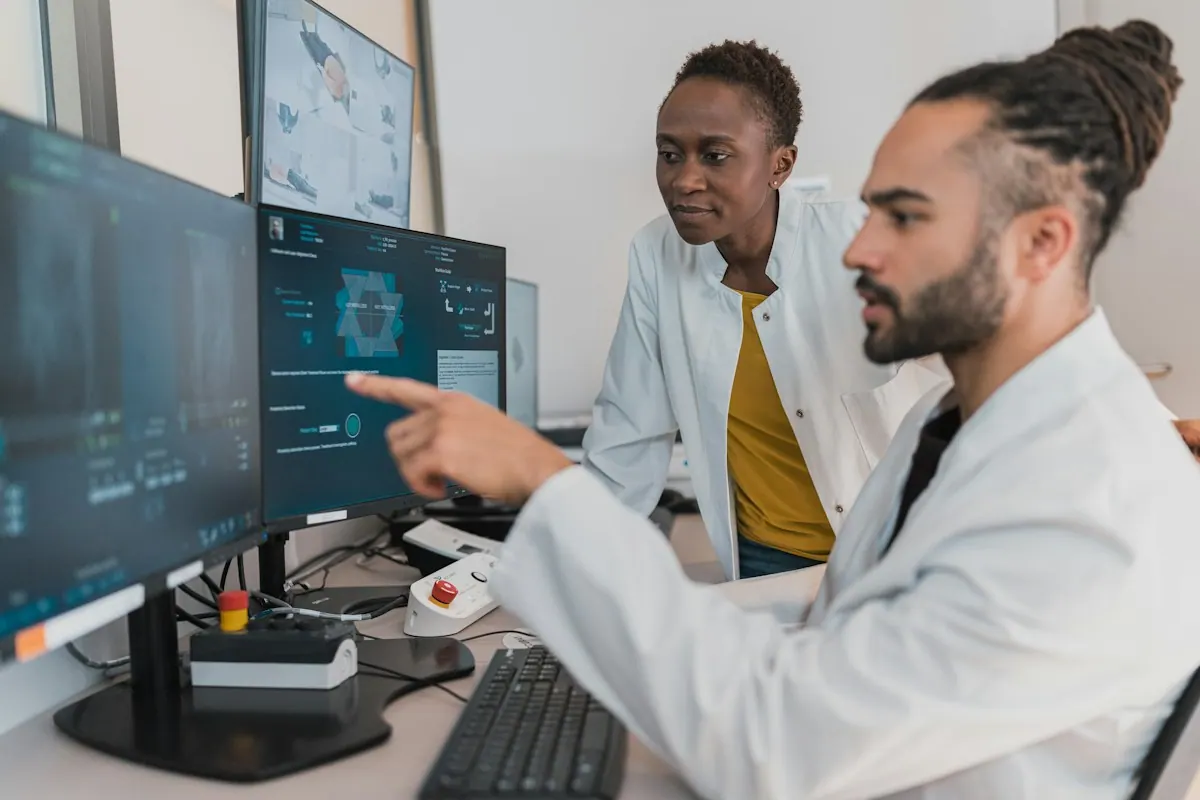 Two clinicians reviewing records at a workstation